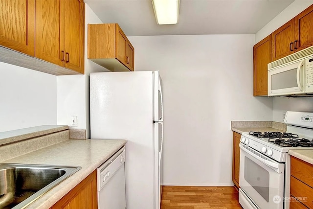 kitchen with light wood-type flooring and white appliances