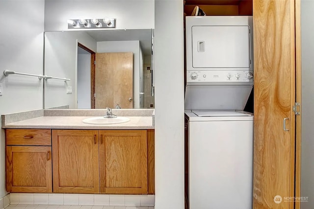 interior space featuring light tile patterned flooring, stacked washing maching and dryer, and sink