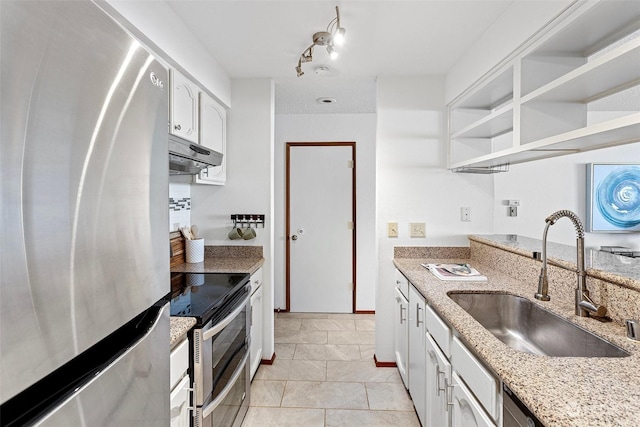 kitchen with appliances with stainless steel finishes, light stone counters, sink, light tile patterned floors, and white cabinets