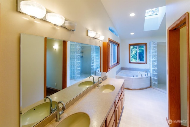 bathroom featuring vanity, a bathtub, and vaulted ceiling with skylight