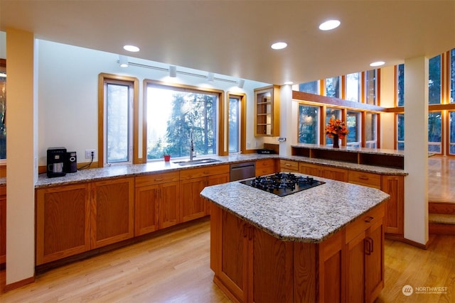 kitchen featuring kitchen peninsula, dishwasher, sink, and light hardwood / wood-style flooring