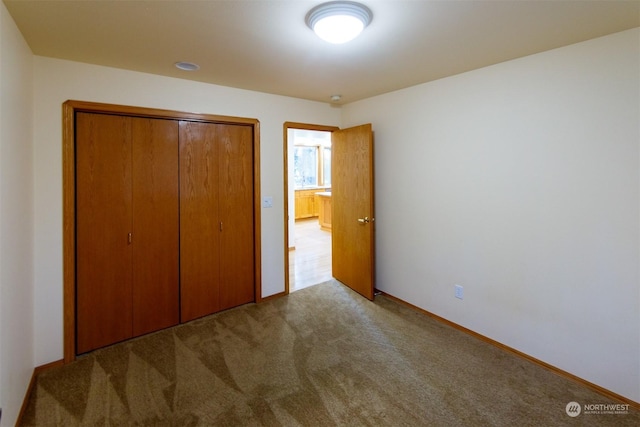 unfurnished bedroom with a closet and light colored carpet