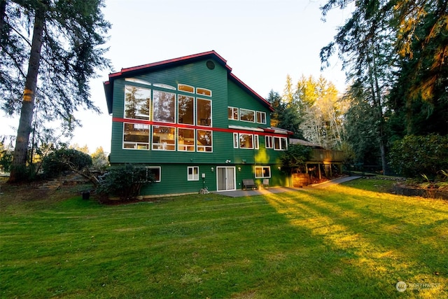 rear view of property featuring a yard and a patio