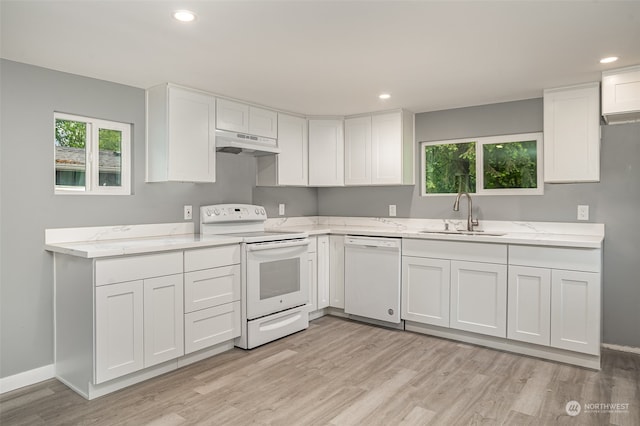 kitchen with white appliances, light hardwood / wood-style floors, white cabinetry, and sink