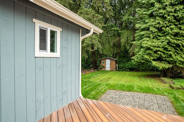 wooden terrace featuring a yard and a storage shed