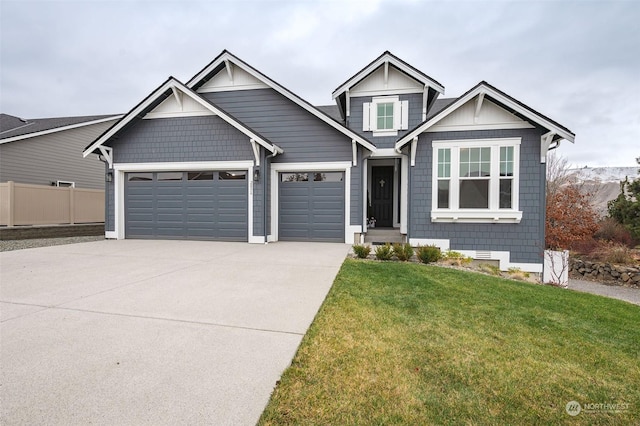 view of front facade with a front yard, concrete driveway, fence, and an attached garage