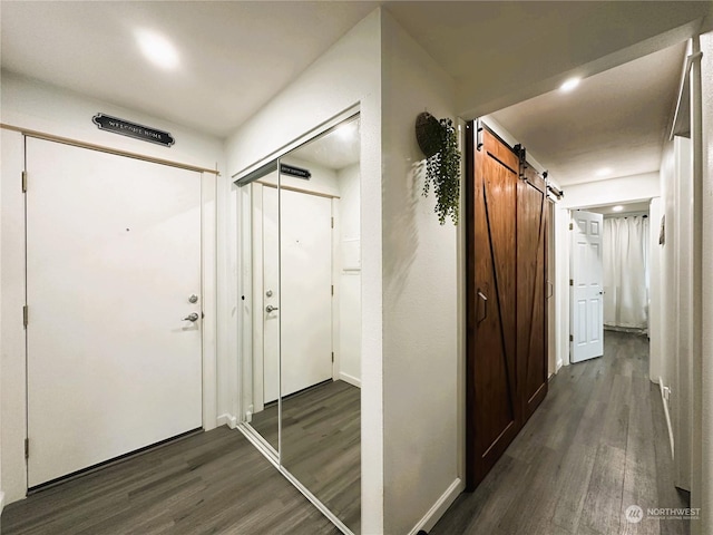 corridor featuring a barn door and dark wood-type flooring