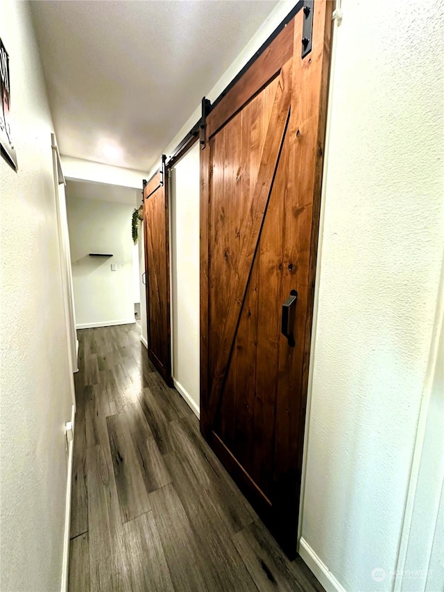 hall featuring a barn door and dark hardwood / wood-style flooring