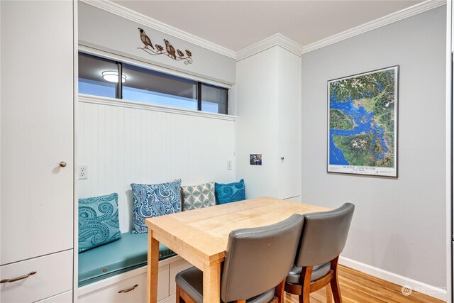 dining area with light hardwood / wood-style floors and ornamental molding