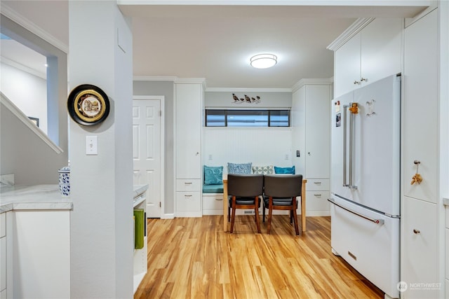 kitchen with white cabinets, light hardwood / wood-style floors, crown molding, and high end white refrigerator