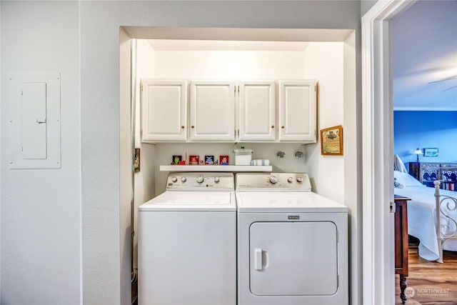 washroom with washing machine and clothes dryer, ceiling fan, cabinets, electric panel, and wood-type flooring