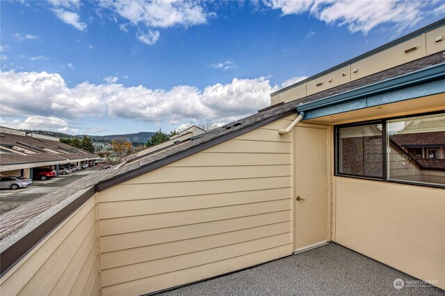 view of side of home featuring a mountain view and a balcony