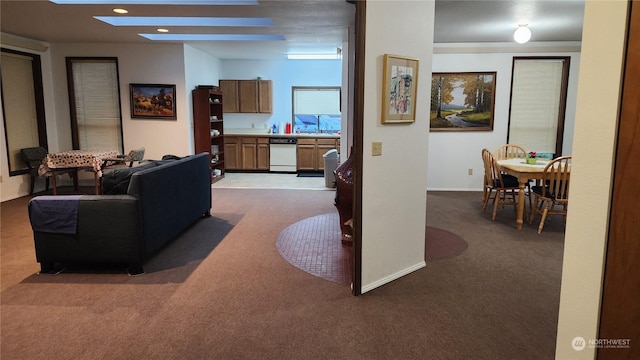 carpeted living room featuring a skylight