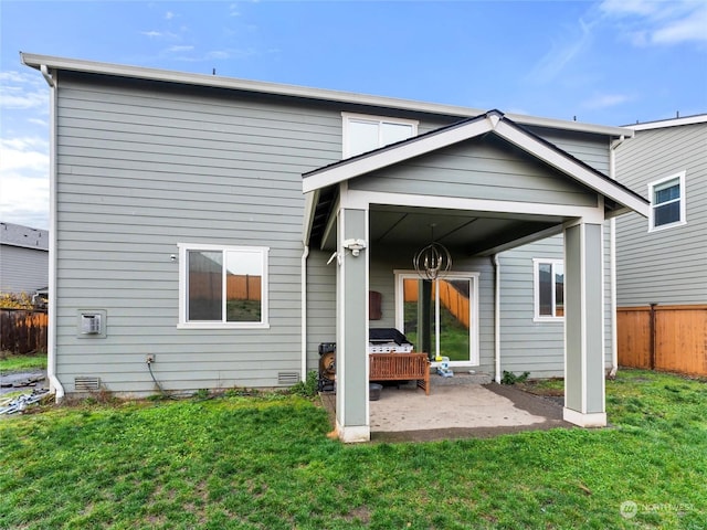 back of house with a lawn and a patio