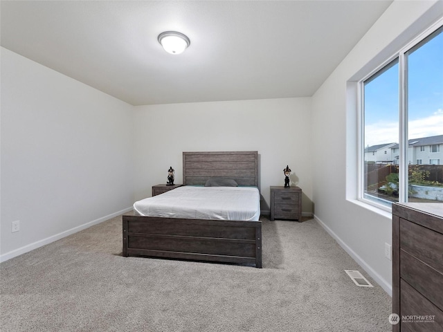 carpeted bedroom featuring multiple windows