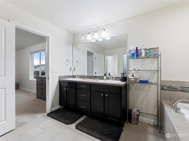 bathroom with tile patterned floors, vanity, and a relaxing tiled tub