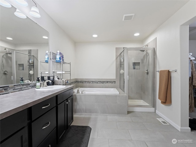 bathroom featuring tile patterned floors, vanity, and shower with separate bathtub