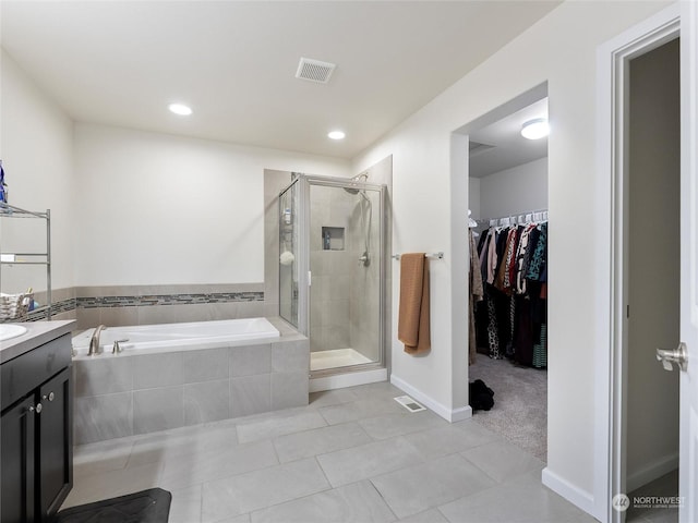 bathroom featuring tile patterned floors, vanity, and plus walk in shower