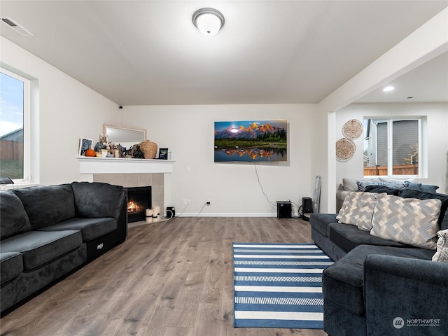 living room featuring hardwood / wood-style flooring and a tiled fireplace