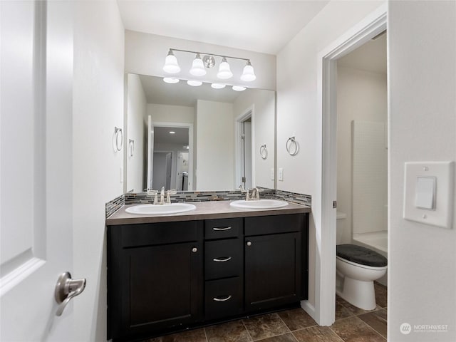 bathroom featuring vanity, toilet, and a shower