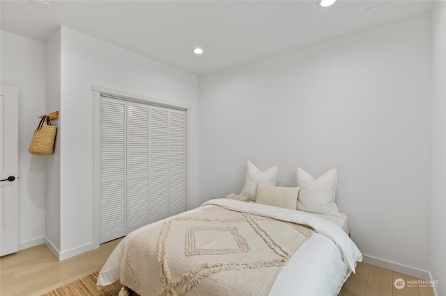 bedroom with light hardwood / wood-style flooring and a closet