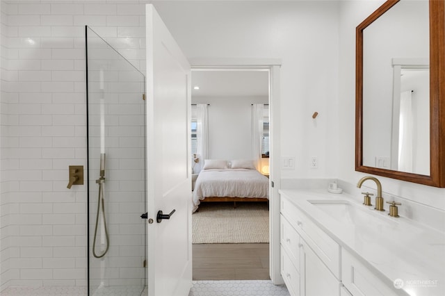 bathroom with tiled shower, vanity, and tile patterned flooring