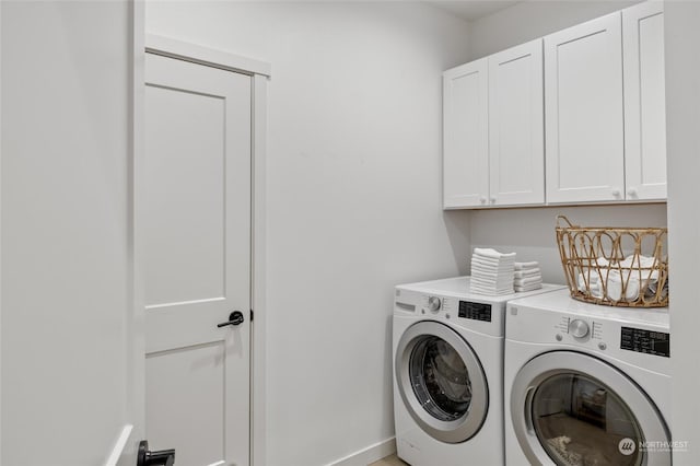 washroom with cabinets and washing machine and clothes dryer