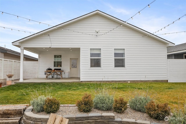 rear view of property featuring a yard and a patio