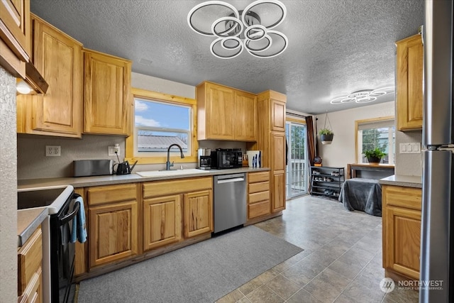 kitchen with sink, stainless steel appliances, and a textured ceiling