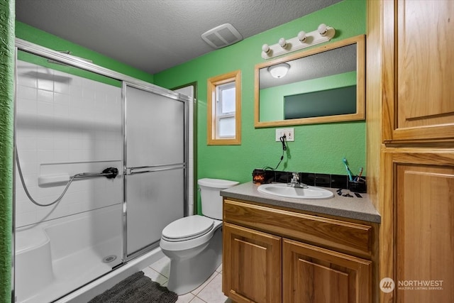 bathroom featuring vanity, tile patterned floors, toilet, a textured ceiling, and a shower with shower door