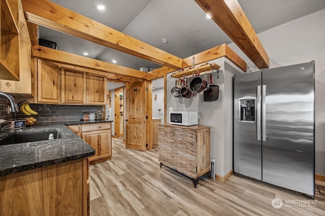 kitchen with backsplash, sink, light wood-type flooring, and stainless steel refrigerator with ice dispenser