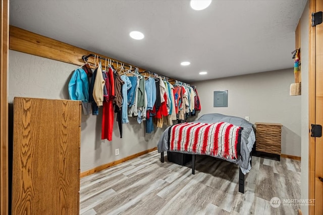 bedroom featuring electric panel and hardwood / wood-style flooring