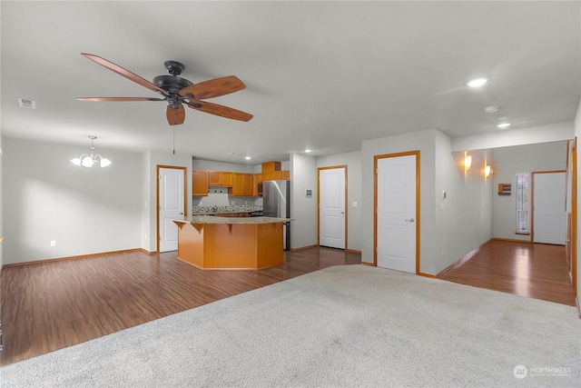 kitchen featuring a kitchen island, decorative light fixtures, light carpet, and ceiling fan with notable chandelier