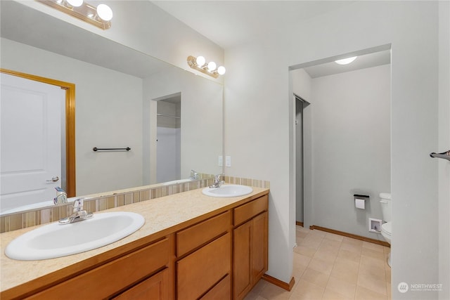 bathroom featuring tile patterned flooring, vanity, and toilet