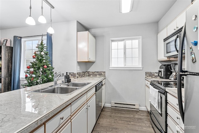 kitchen with white cabinetry, sink, dark wood-type flooring, hanging light fixtures, and stainless steel appliances