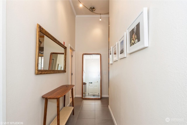 hall featuring crown molding and dark tile patterned flooring