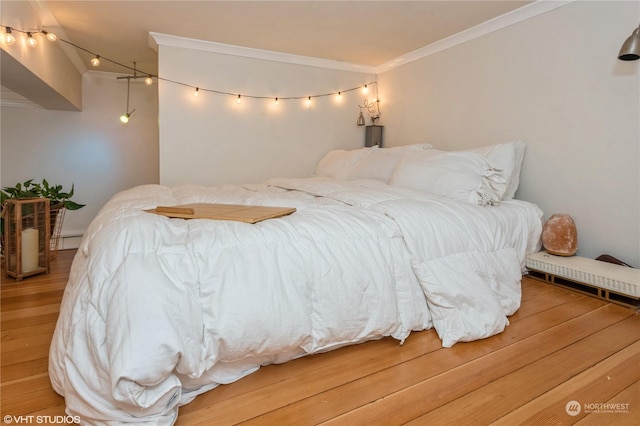 bedroom with hardwood / wood-style floors and ornamental molding