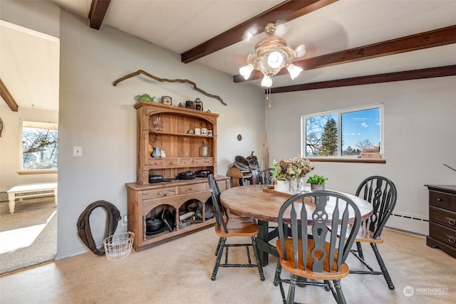 carpeted dining space with vaulted ceiling with beams, plenty of natural light, ceiling fan, and a baseboard radiator