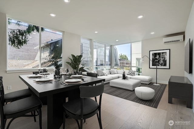 dining room with light hardwood / wood-style floors and a wall mounted air conditioner