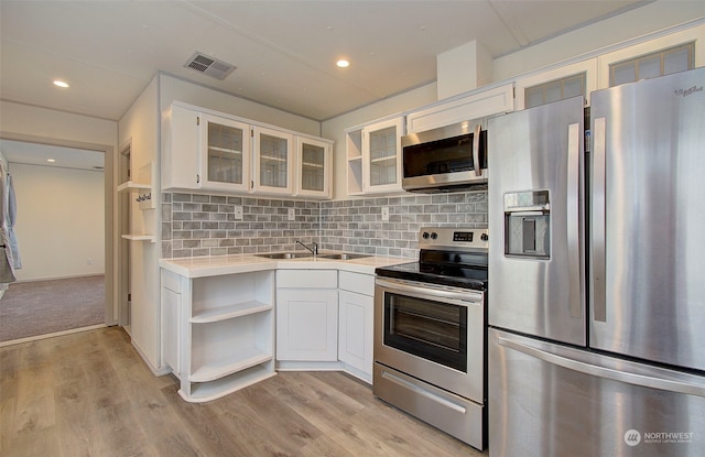 kitchen with white cabinets, light hardwood / wood-style floors, and appliances with stainless steel finishes