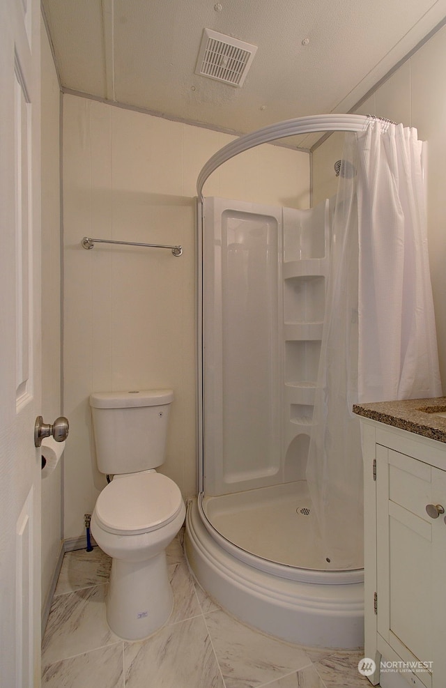 bathroom featuring a shower with shower curtain, vanity, toilet, and a textured ceiling