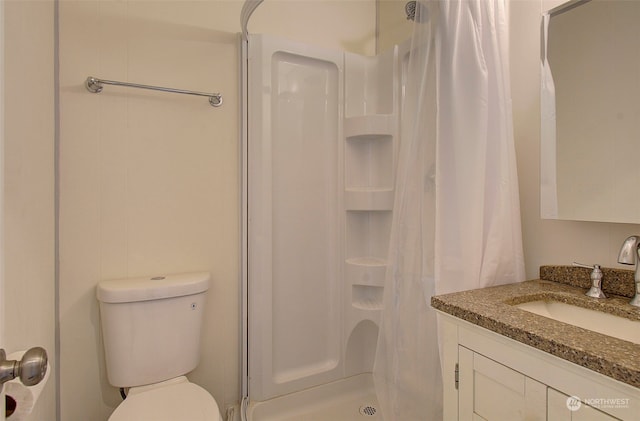 bathroom featuring curtained shower, vanity, and toilet