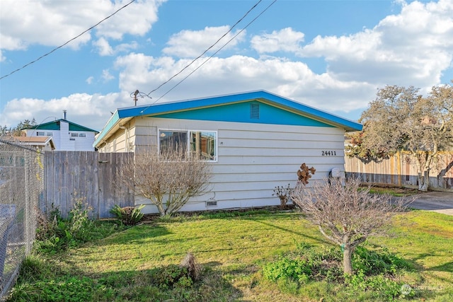 view of side of home with a yard