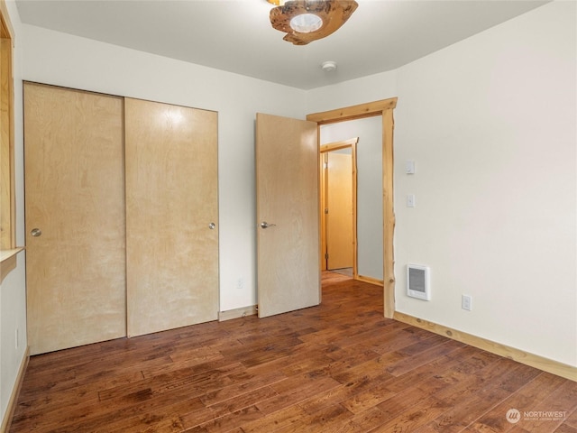 unfurnished bedroom featuring a closet and dark hardwood / wood-style flooring