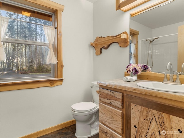 bathroom with toilet, walk in shower, and vanity