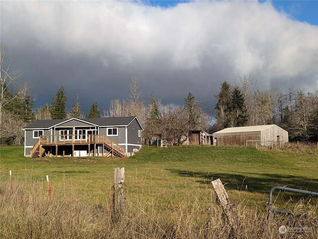 back of property featuring a deck, a yard, and stairway