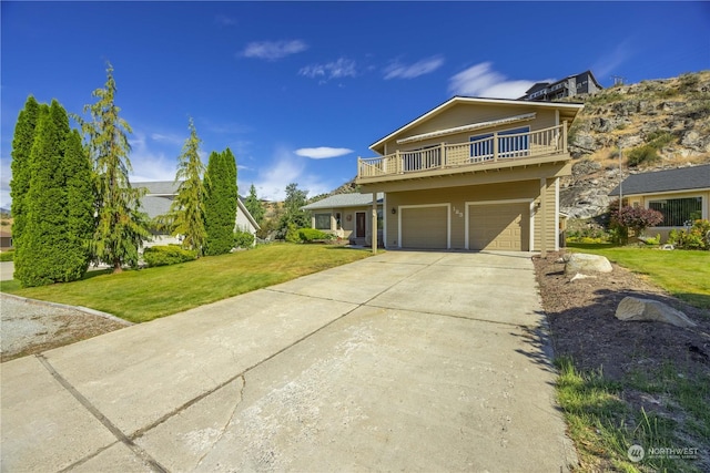 front of property featuring a garage, a balcony, and a front lawn