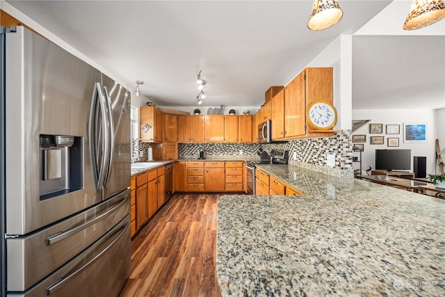 kitchen featuring pendant lighting, dark hardwood / wood-style flooring, kitchen peninsula, and appliances with stainless steel finishes