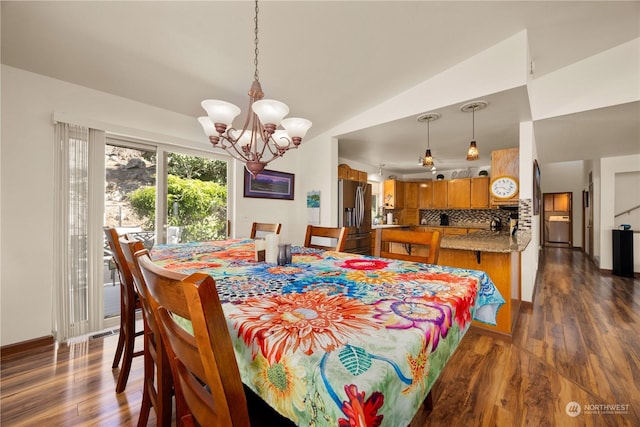 dining space with dark hardwood / wood-style floors, lofted ceiling, and an inviting chandelier