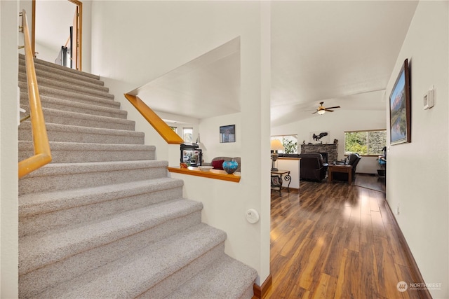 stairway featuring hardwood / wood-style floors, ceiling fan, and vaulted ceiling